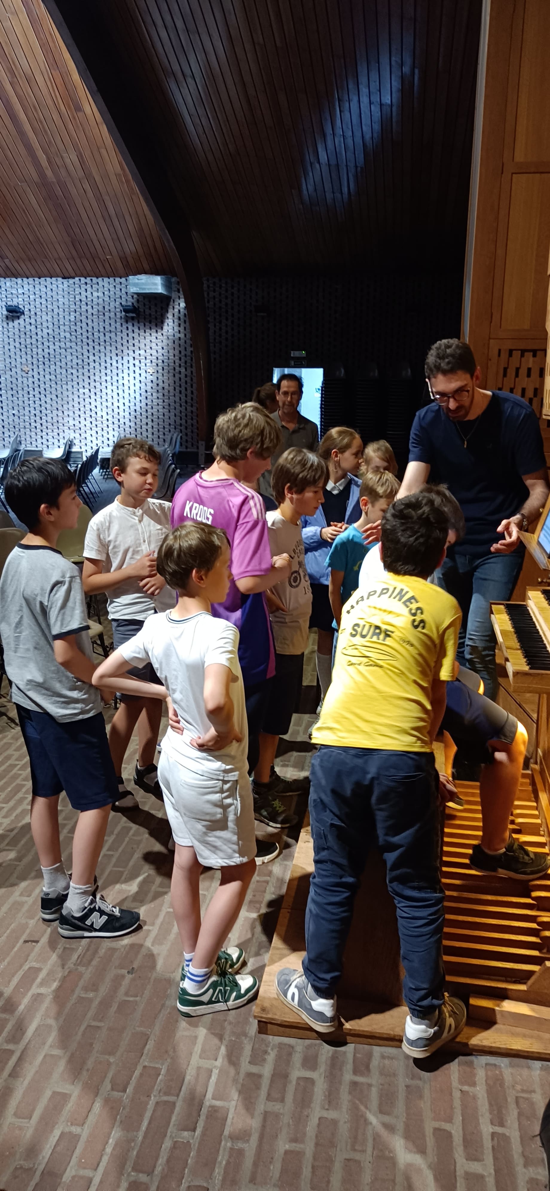 Enfants attentifs devant les tuyaux et le pédalier de l'orgue